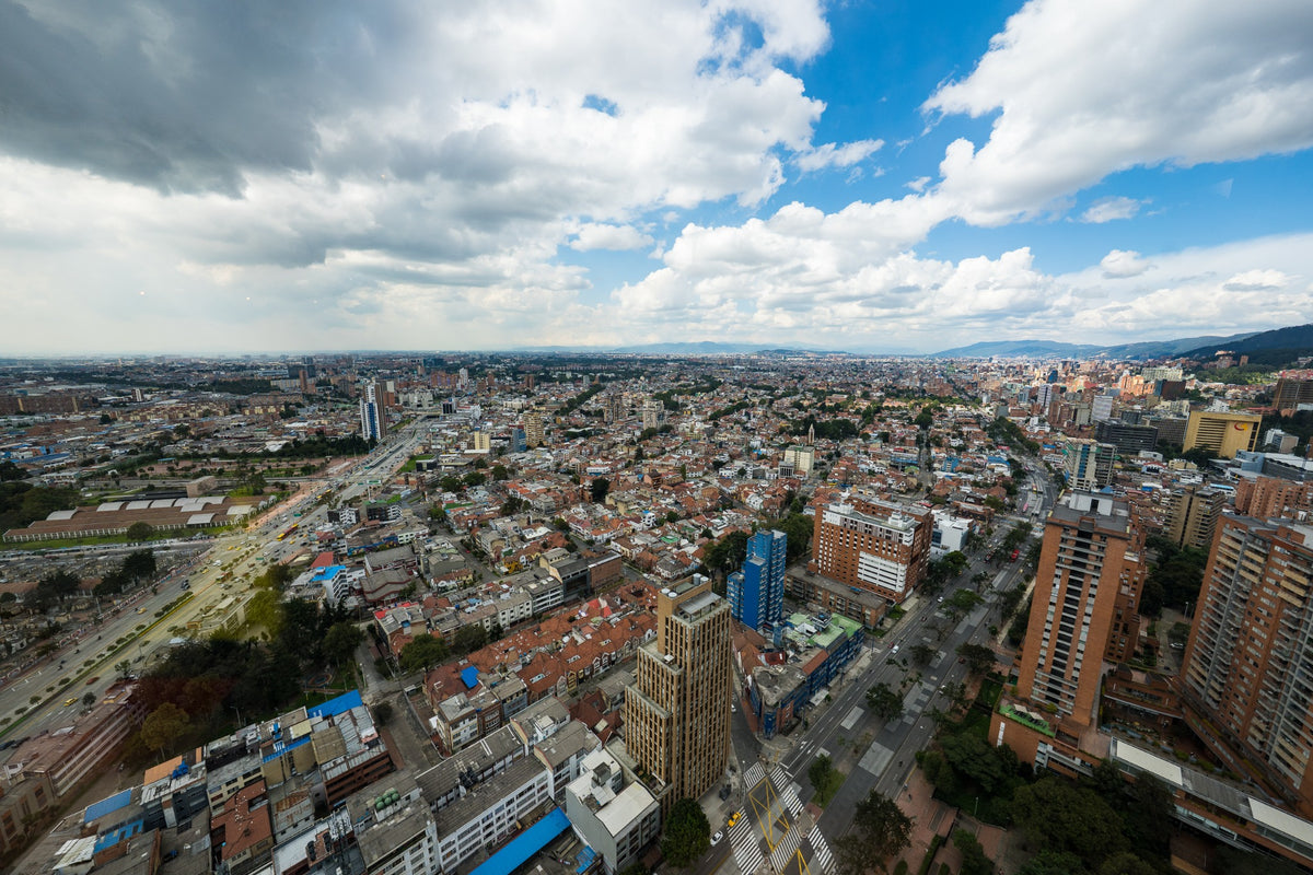 An expansive panorama of Bogotá’s streets and rooftops under shifting clouds.