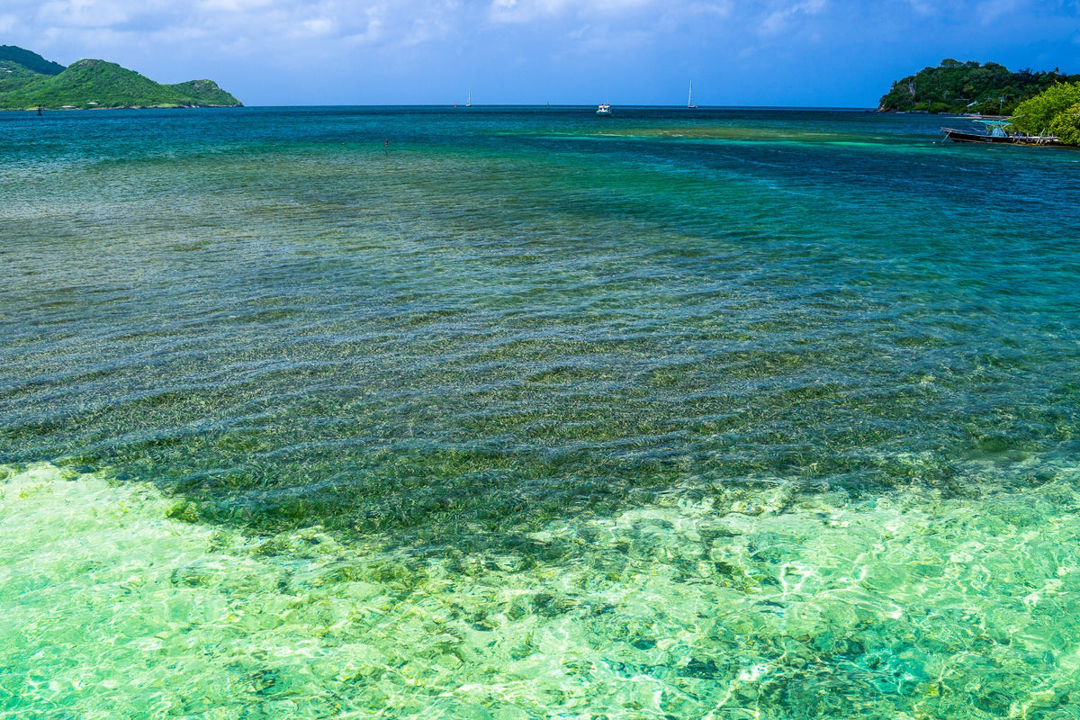 Clear emerald water between green island shores.